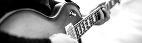 Lehrer spielt E-Gitarre - Detailaufnahme